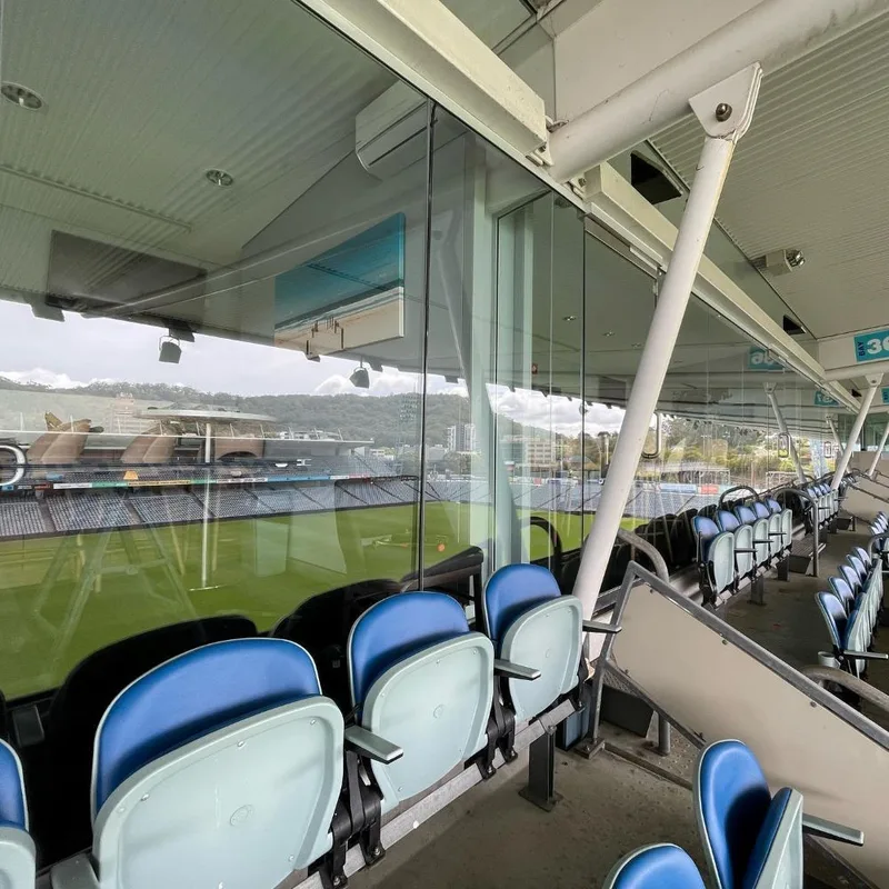 Large commercial glass panels installed beside stadium seating