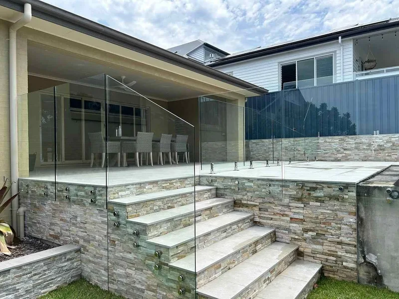 Glass balustrades around a raised terrace and outdoor steps