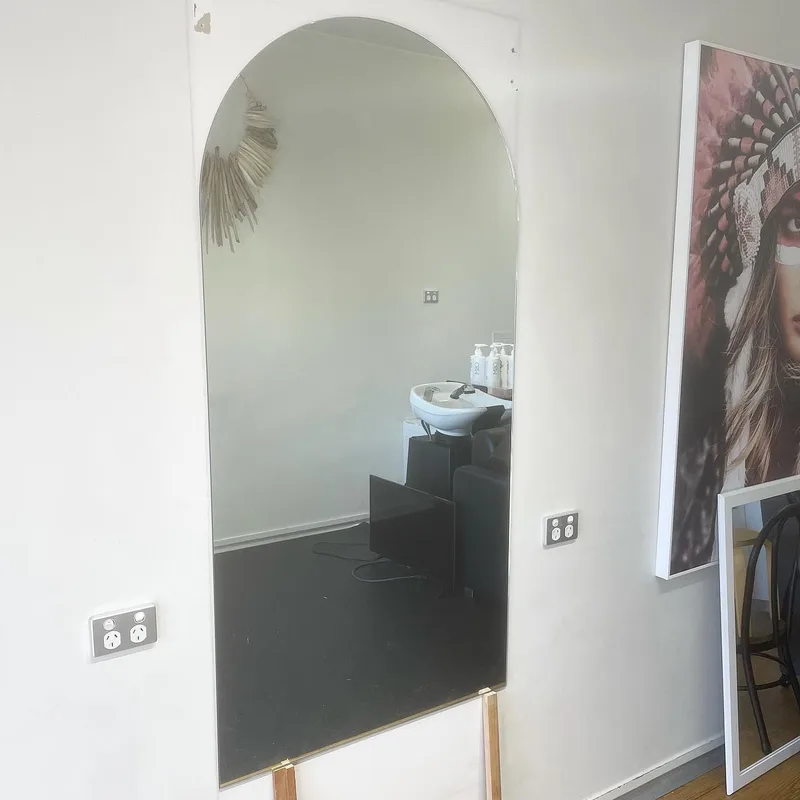 Large custom arched mirror fitted to a salon wall