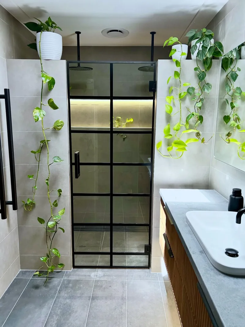 Black framed custom shower screen with hanging plants in a Lisarow bathroom