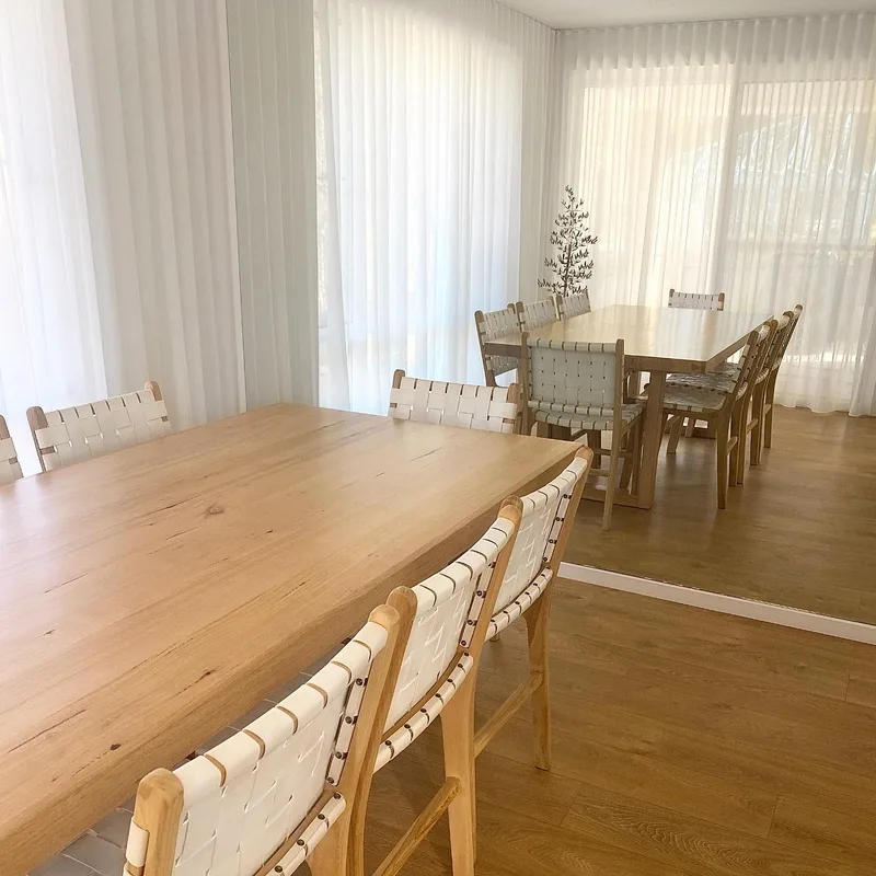 Large wall mirror reflecting a light filled dining area